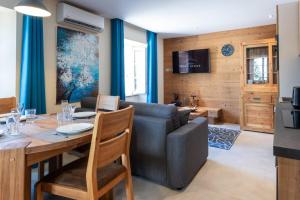 a dining room and living room with a table and a couch at OURAL Annecy Rent Lodge in Annecy