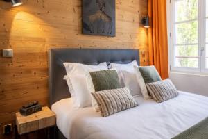 une chambre avec un lit avec des draps blancs et des oreillers dans l'établissement OURAL Annecy Rent Lodge, à Annecy 13 autres photos