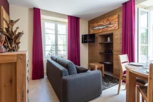 salon z czerwonymi zasłonami i kanapą w obiekcie CARPATES Annecy Rent Lodge w Annecy