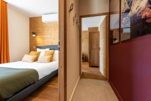 a bedroom with a large bed and a hallway at CARPATES Annecy Rent Lodge in Annecy