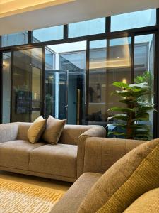 uma sala de estar com dois sofás e uma planta em Riyadh Boulevard Luxury Apartment em Riyadh