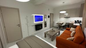 a living room with an orange couch and a kitchen at breath studio in Giannitsa