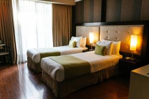 duas camas num quarto de hotel com duas lâmpadas em BENS - Recoleta Park em Buenos Aires