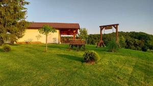 a garden with a picnic table in the grass at Kuća za odmor PICCOLINA in Vinica