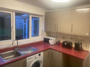 a kitchen with a sink and a washing machine at 4 Bed Comfy House in Birmingham in Birmingham