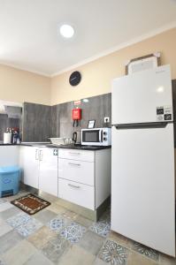 eine Küche mit weißen Schränken und einem Kühlschrank in der Unterkunft Suites DP Setúbal in Setúbal