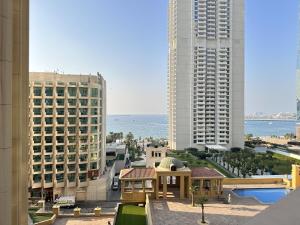 a view of a city with buildings and the ocean at Bollywood Beach Hostel in Dubai