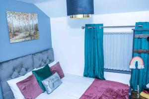 a bedroom with a bed with blue walls at Luxurious 5-Beds House in Dudley in Dudley