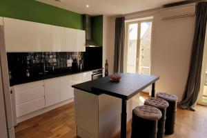una cucina con tavolo nero e armadietti bianchi di Duplex 4 pers, plein centre de Montignac-Lascaux a Montignac