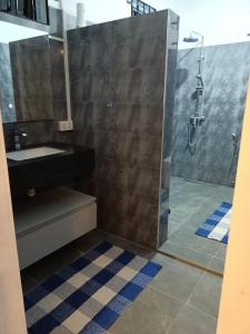 La salle de bains est pourvue d'un lavabo et d'une douche. dans l'établissement Cozy Lodge, à Grand Gaube