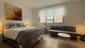 ein Schlafzimmer mit einem Bett und einer Couch in der Unterkunft Room Pinar - Apartamento con todas las comodidades - VT 14178 in Madrid