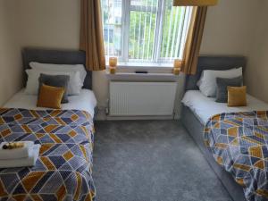 a room with two beds and a window at 5Bed House Wirral near Liverpool Chester in Wirral