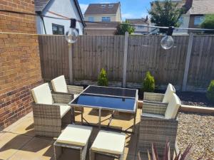 un patio con mesa, sillas y una valla en 5Bed House Wirral near Liverpool Chester, en Wirral