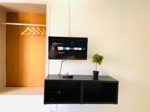 a black cabinet with a tv on a wall at Central Atlantic Beach Guesthouse in Costa da Caparica