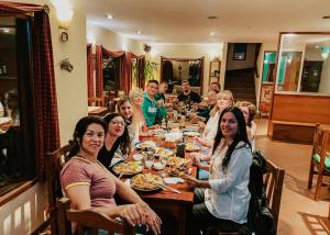 grupa ludzi siedzących przy stole jedzących jedzenie w obiekcie Lupama w mieście El Calafate