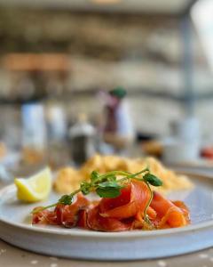 a plate of food with shrimp and a slice of lemon at Isle of Raasay Distillery in Raasay