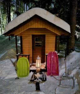 ein kleines Haus im Schnee mit einer Kerze davor in der Unterkunft Spacious house in Rovaniemi / Lapland (11 beds) in Rovaniemi