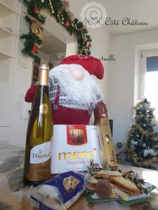 a bottle of wine and some food and a christmas tree at Coquette Maison, Côté Château à Mutzig en Alsace in Mutzig