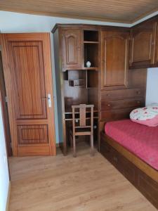 a bedroom with a bed and a desk with a chair at Casa Nelito in Pedrógão Grande