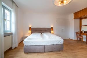ein Schlafzimmer mit einem großen Bett und einem Schreibtisch in der Unterkunft Weingut Köfelgut - Turris Vini in Kastelbell