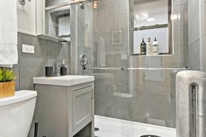 a bathroom with a shower with a toilet and a sink at Great Value Lakeview 2-Bedroom Condo - Oakdale E2 E1 rep in Chicago
