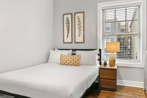 a white bedroom with a bed and a window at Great Value Lakeview 2-Bedroom Condo - Oakdale E2 E1 rep in Chicago
