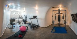 una habitación con un gimnasio con equipamiento de ejercicio. en Elite Luxury Suites en Oia