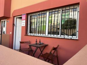 una mesa y sillas sentadas frente a un edificio en Casa Orange Piscine Terrasse Parking, en San Sebastián de la Gomera