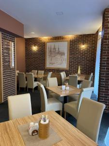 um restaurante com mesas e cadeiras e uma parede de tijolos em Hotel U města Prahy Náchod em Náchod