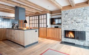 a kitchen with a stone wall and a fireplace at Lech Lodge - 3 Chalets und eine "Gute Fee" in Lech am Arlberg