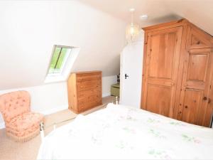 a bedroom with a bed and a chair and a window at 1 Bed in Curbar PK455 in Curbar