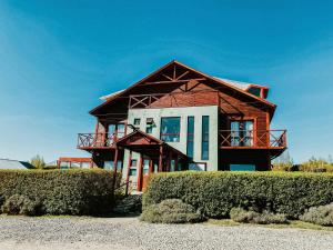 a wooden house with a balcony on top of it at Lupama in El Calafate