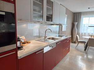 una cocina con armarios rojos y fregadero en Apartment Sonntagskind, en Seekirchen am Wallersee