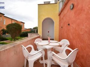 uma mesa branca e cadeiras sentadas numa varanda em Le residenze Itaca em Porto Pozzo
