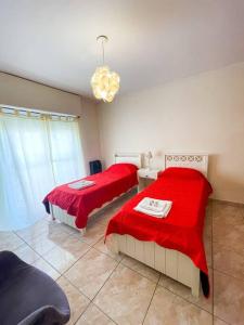een slaapkamer met 2 bedden met rode lakens en een kroonluchter bij Namuncura 646 by depptö in Bahía Blanca