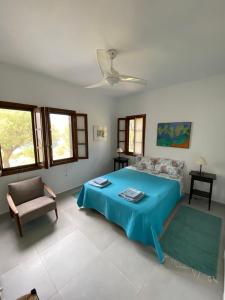 Un dormitorio con una cama azul y una silla. en Aspro Spiti 1, en Ormos Panagias
