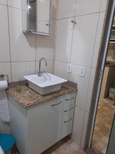 ein Badezimmer mit einem weißen Waschbecken und einem Spiegel in der Unterkunft Casa temporada in Búzios