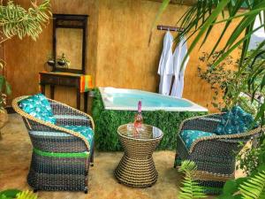 a bathroom with a tub with two chairs and a table at #16 Stylish Rustic Studio & Outdoor JACUZZI in Fortuna