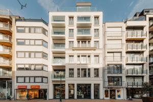 un condominio alto e bianco con molte finestre di Portwin luxury stays a Knokke-Heist