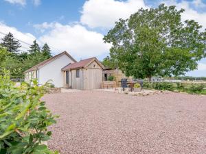 a barn conversion with a gravel driveway and a tree at 2 Bed in Newent 78696 in Aston Ingham