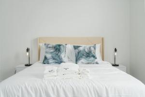 a white bed with two folded towels on it at Corporate Housing by MGM in Whitestown