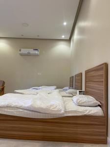 1 dormitorio con 1 cama grande con sábanas blancas en مزرعة المدائن, en Madain Saleh