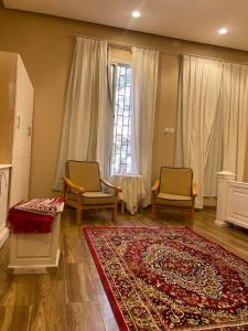 sala de estar con 2 sillas y alfombra en مزرعة المدائن, en Madain Saleh