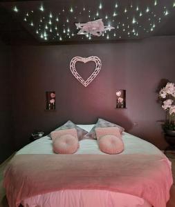 a bedroom with a bed with a heart sign on the wall at L'Ecrin duplex balnéo & Sauna in Troyes