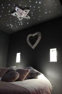 a bedroom with a bed with a heart on the wall at L'Ecrin duplex balnéo & Sauna in Troyes