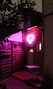 a pink lighted building with a table and a chair at L'Ecrin duplex balnéo & Sauna in Troyes