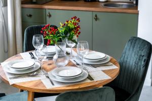 - une table en bois avec des assiettes, des verres et des fleurs dans l'établissement DejaVu, à Novi Sad