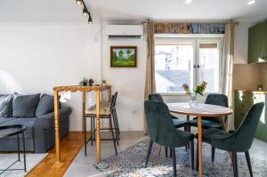 un salon avec une table, des chaises et un canapé dans l'établissement DejaVu, à Novi Sad