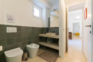 a bathroom with a toilet and a sink and a mirror at Sorelle di Riviera in Syracuse