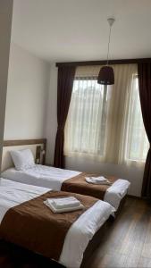 una camera d'albergo con due letti e una finestra di БЯЛАТА КЪЩА a Kirkovo